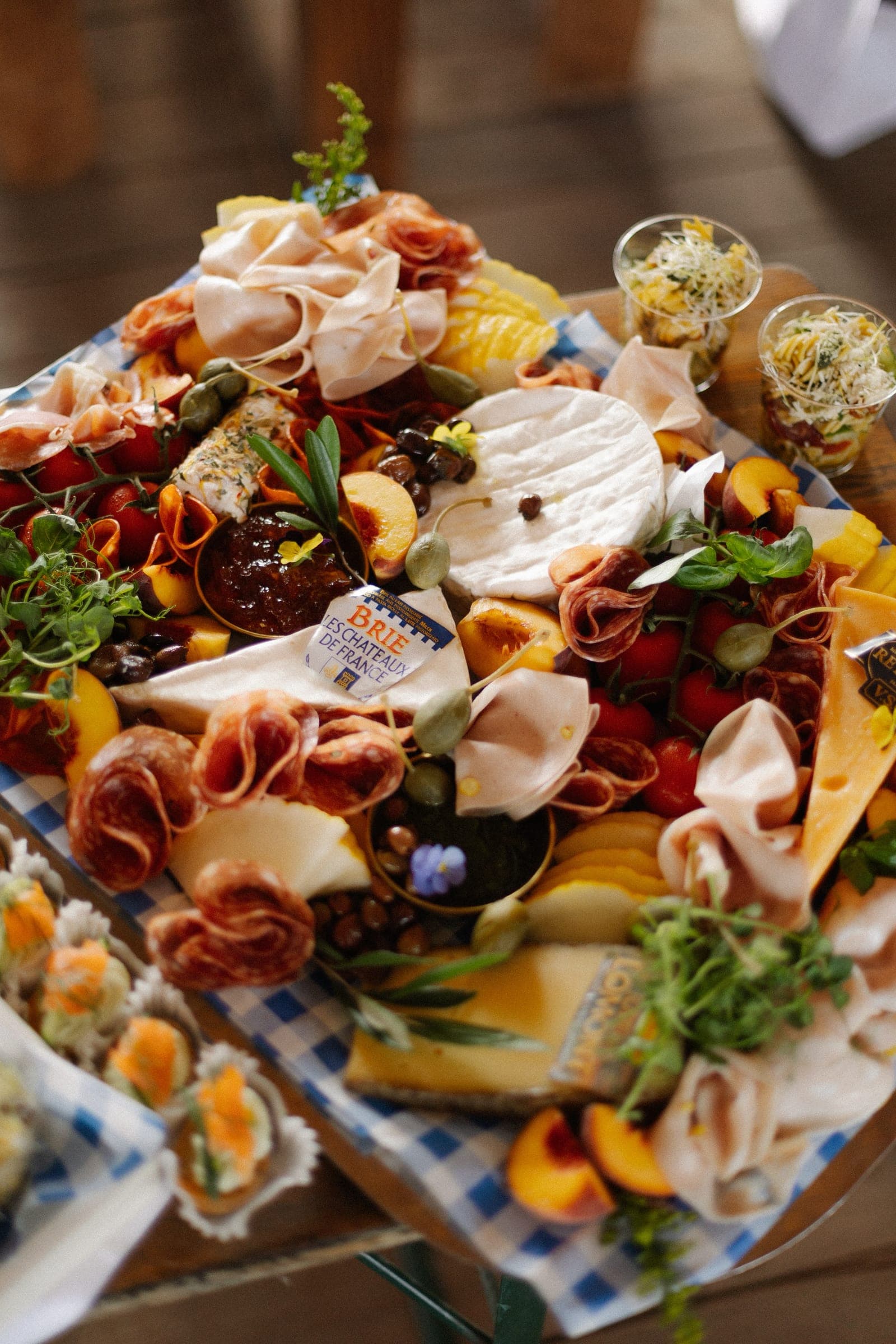Charcuterie prkno se sýry, italskými uzeninami, broskvemi a olivami